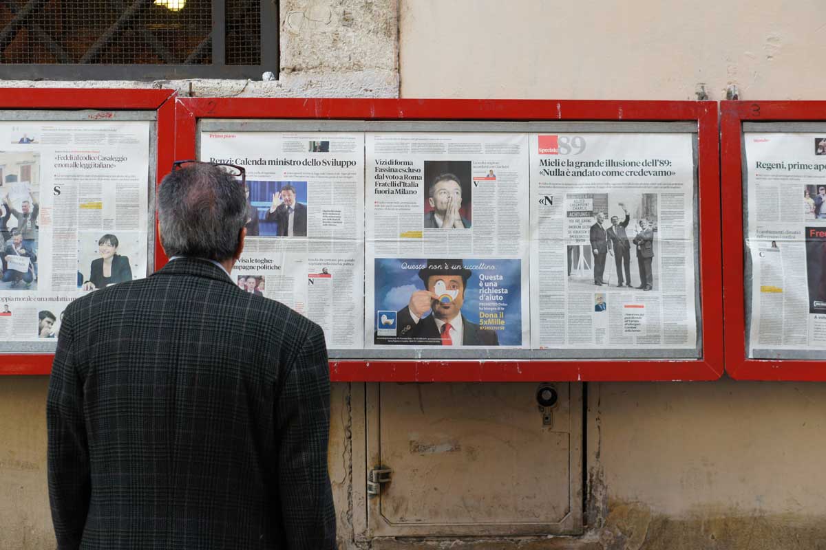 man reading newspaper posted on a public display